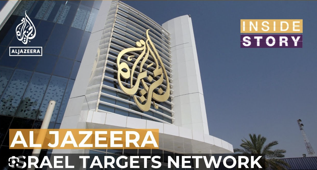 A modern building with the large gold Al Jazeera logo on glass, the Al Jazeera and Inside Story logos, and text reading AL JAZEERA ISRAEL TARGETS NETWORK. Palm trees and sky are visible.